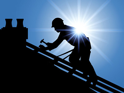 Ein Dachdecker, der auf einem Dach arbeitet, silhouettiert vor einer strahlenden Sonne.